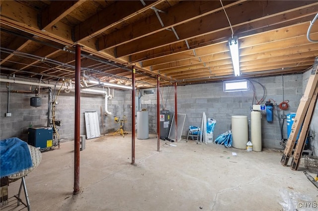 basement featuring electric water heater and water heater