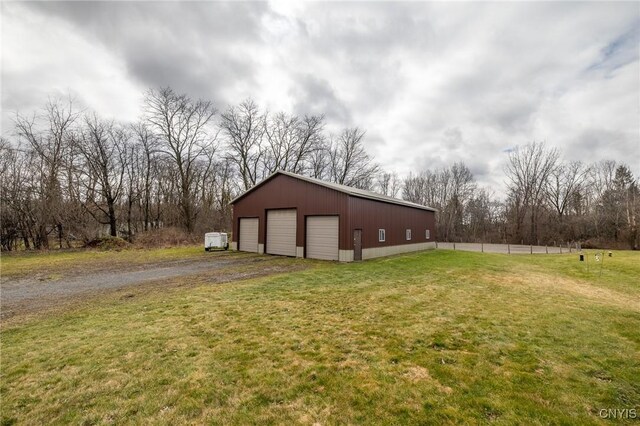 view of side of home with a garage, an outdoor structure, and a yard