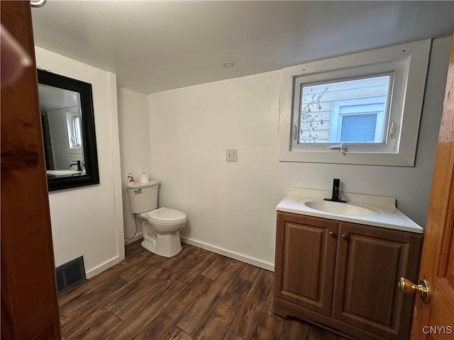 bathroom featuring vanity, hardwood / wood-style floors, and toilet