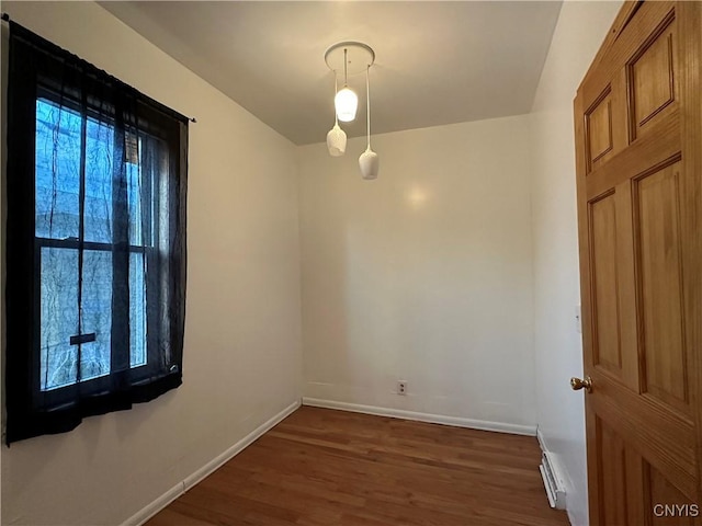 empty room featuring dark hardwood / wood-style flooring and a baseboard radiator