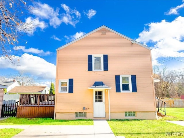 back of property with a deck and a lawn