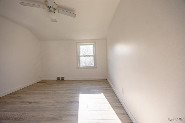 spare room featuring light wood-type flooring, ceiling fan, and lofted ceiling