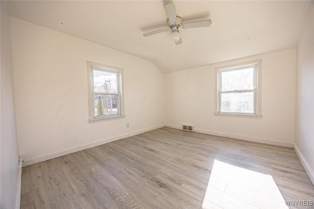 empty room with ceiling fan, light hardwood / wood-style floors, and lofted ceiling