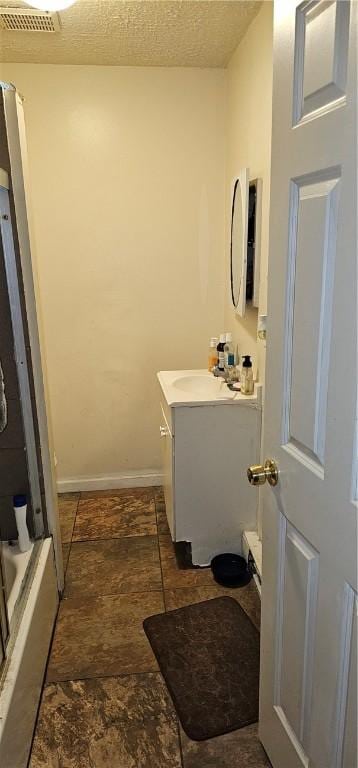 bathroom featuring a textured ceiling and vanity