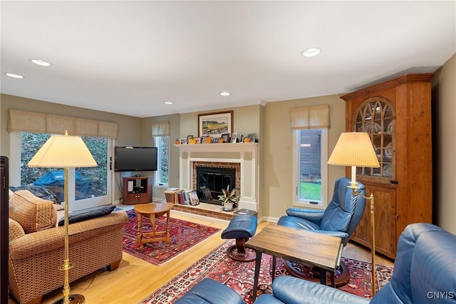 living room featuring hardwood / wood-style floors and a brick fireplace