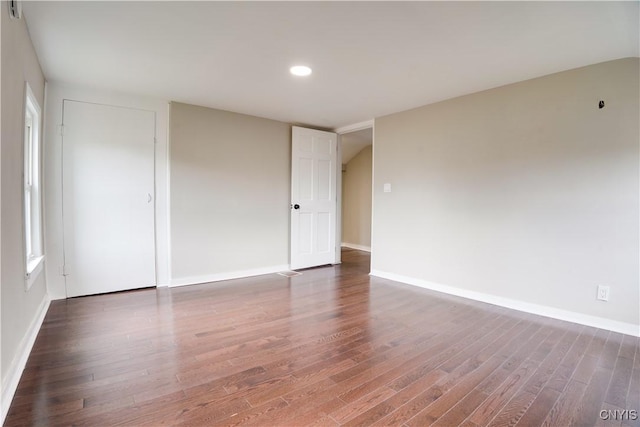 unfurnished room with dark hardwood / wood-style flooring