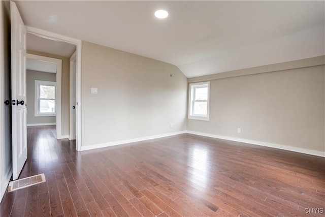 unfurnished room with lofted ceiling and dark wood-type flooring