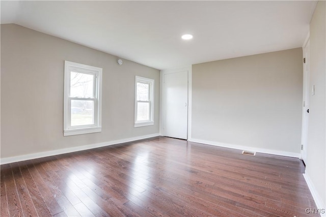 empty room featuring dark hardwood / wood-style flooring and vaulted ceiling