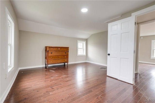 empty room with dark wood-type flooring and vaulted ceiling