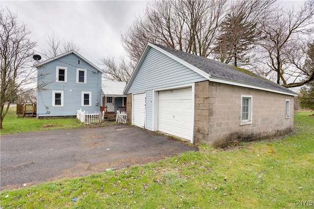 view of side of home with an outbuilding, a yard, a garage, and a deck