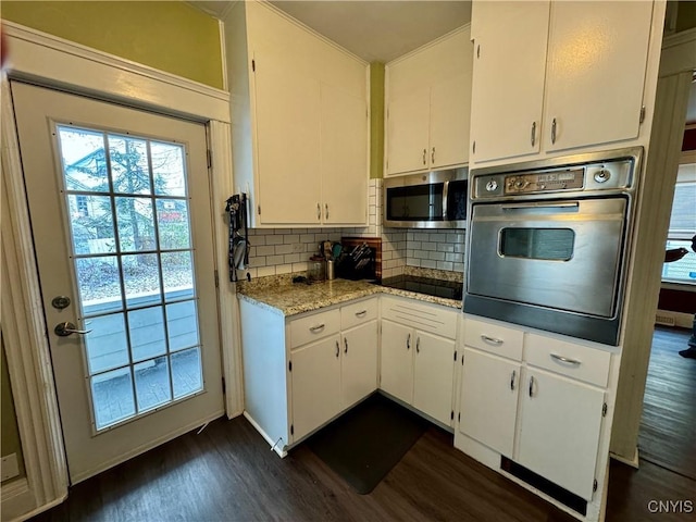 kitchen featuring dark wood-type flooring, tasteful backsplash, light stone counters, white cabinets, and black appliances