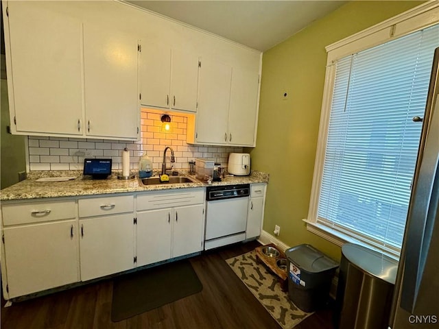 kitchen with white cabinetry, sink, dark hardwood / wood-style floors, white dishwasher, and decorative backsplash