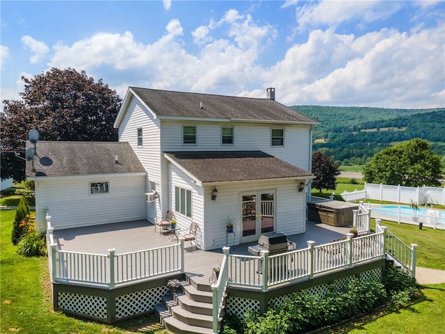 rear view of property with a pool side deck