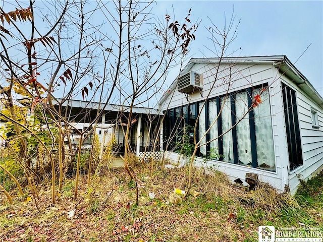 view of home's exterior with an AC wall unit