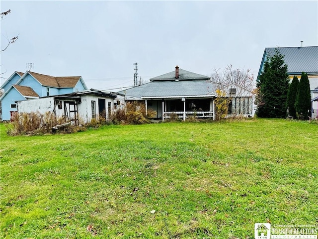 rear view of property featuring a yard