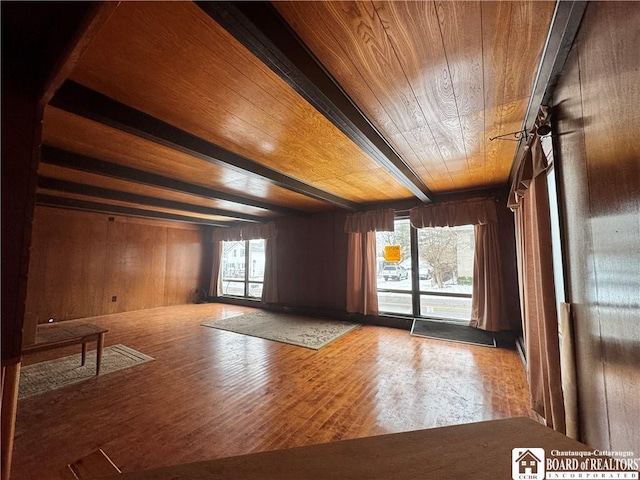 spare room with beamed ceiling, hardwood / wood-style floors, plenty of natural light, and wood ceiling