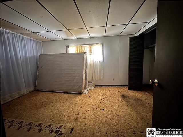 basement featuring carpet flooring and a paneled ceiling