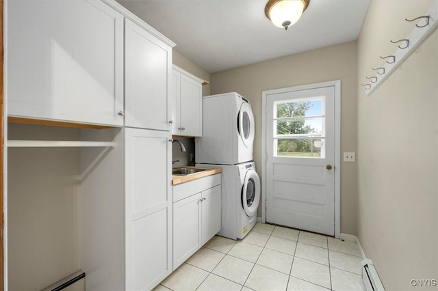 laundry room with sink, cabinets, a baseboard heating unit, stacked washer / drying machine, and light tile patterned flooring