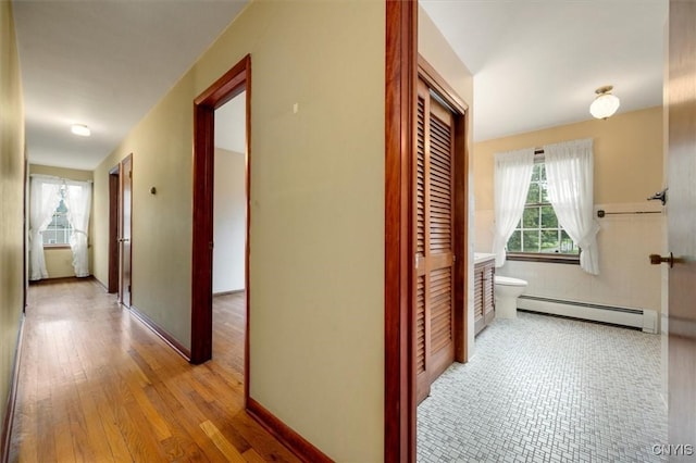 corridor featuring a baseboard radiator and light wood-type flooring