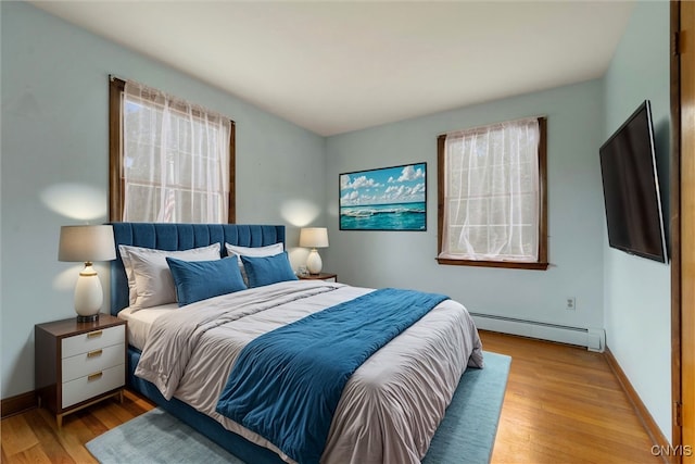 bedroom featuring light hardwood / wood-style flooring and baseboard heating