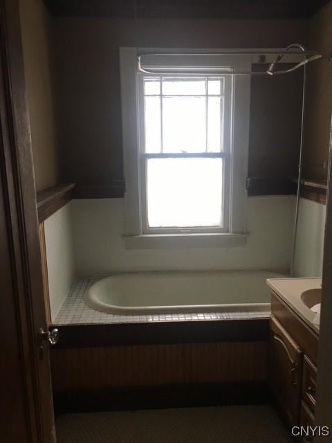 bathroom featuring vanity and a tub to relax in