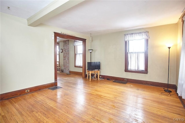 unfurnished room featuring beam ceiling and light wood-type flooring