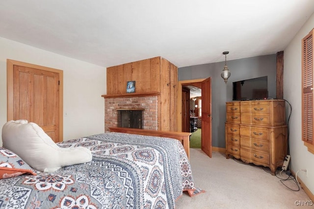 bedroom with a closet, light colored carpet, and a brick fireplace