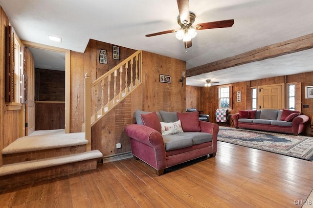 living room featuring wooden walls, ceiling fan, and hardwood / wood-style flooring