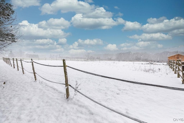 snowy yard featuring a rural view