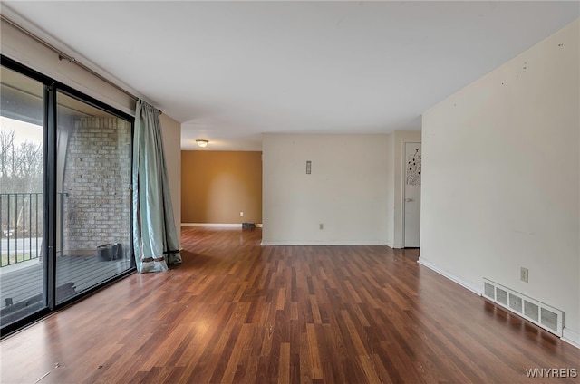 empty room featuring plenty of natural light and dark hardwood / wood-style floors