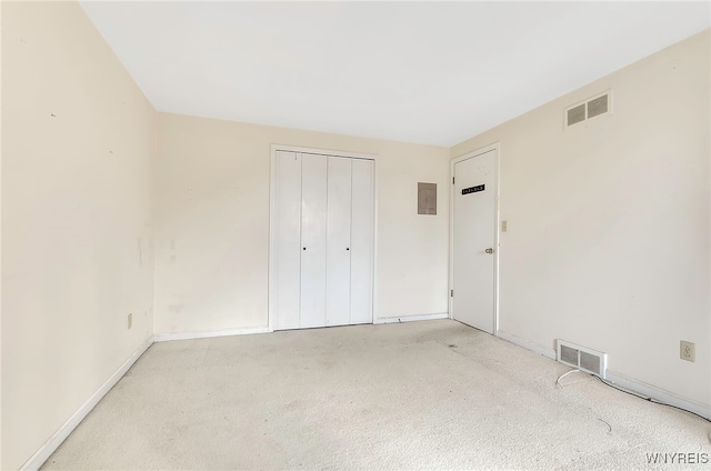 unfurnished bedroom featuring light carpet and a closet