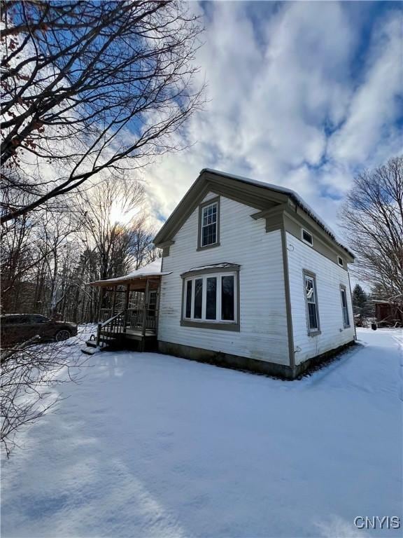 view of snow covered exterior featuring a porch