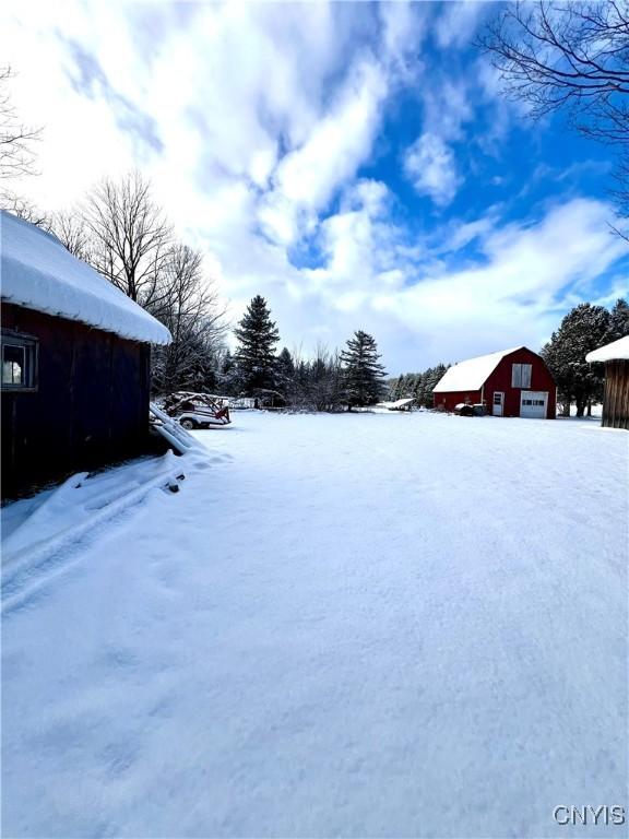 yard covered in snow with an outbuilding