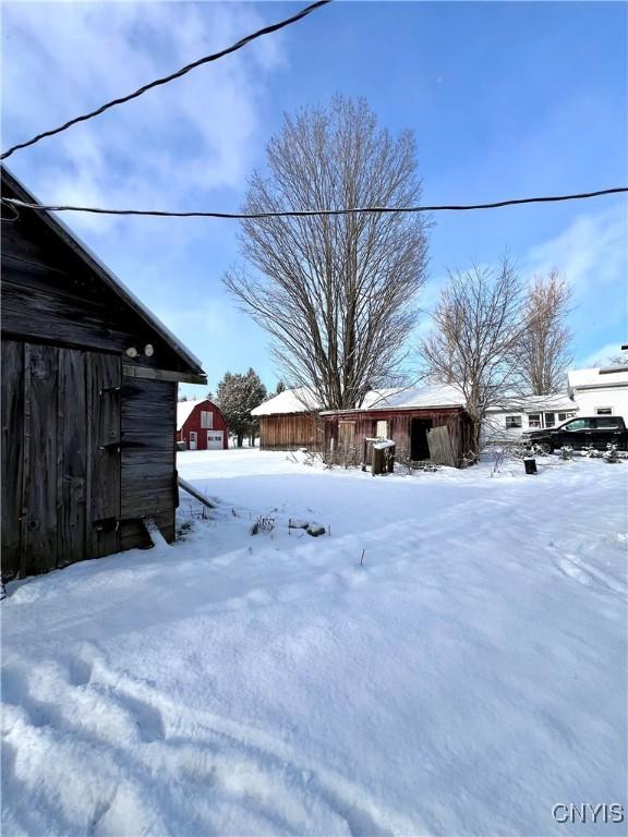 yard covered in snow featuring an outbuilding