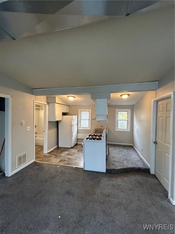 kitchen with white cabinets, carpet flooring, and white appliances