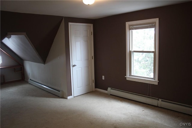 additional living space featuring light carpet and a baseboard heating unit