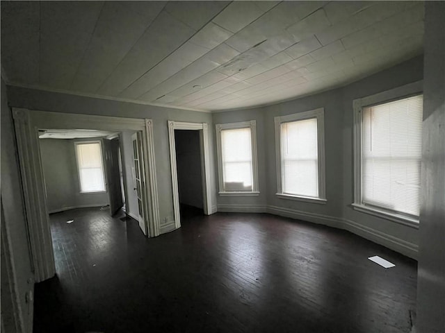 unfurnished room featuring dark hardwood / wood-style floors and plenty of natural light