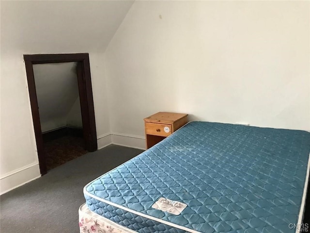 bedroom featuring dark carpet and vaulted ceiling