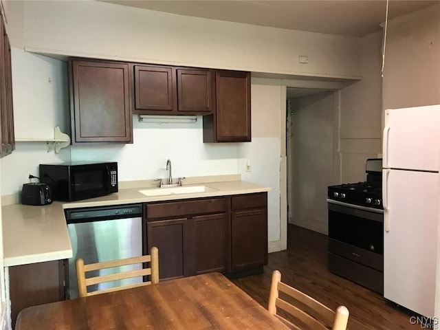 kitchen featuring dark wood-type flooring, dark brown cabinetry, sink, and black appliances