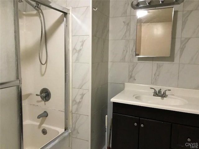 bathroom featuring tile walls, vanity, and bathtub / shower combination