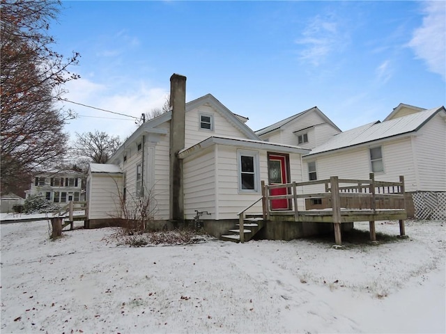 snow covered house with a deck