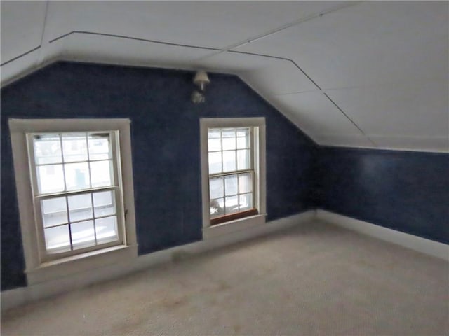 bonus room with carpet flooring and vaulted ceiling