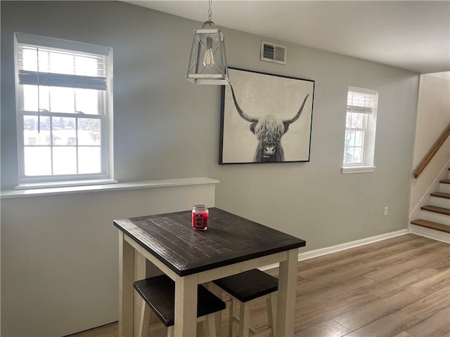 dining room featuring a healthy amount of sunlight and light hardwood / wood-style floors