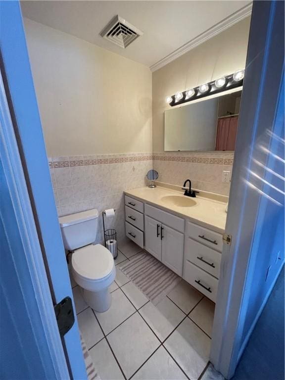 bathroom featuring vanity, crown molding, tile walls, tile patterned flooring, and toilet