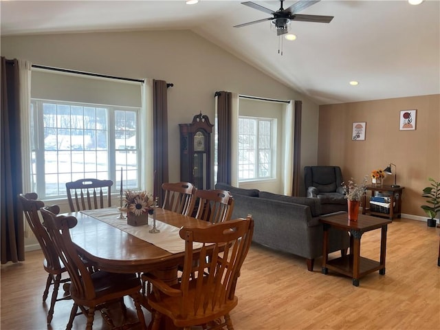 dining room featuring ceiling fan, light wood-type flooring, and vaulted ceiling