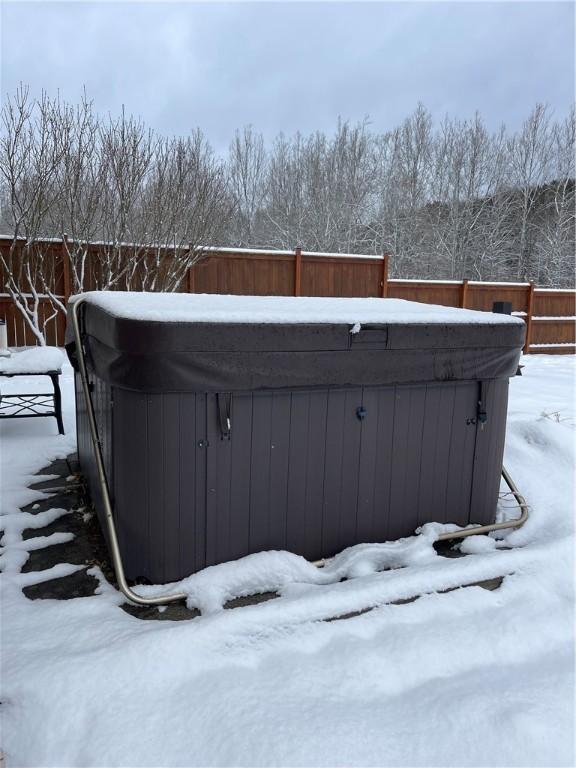 yard covered in snow with a hot tub