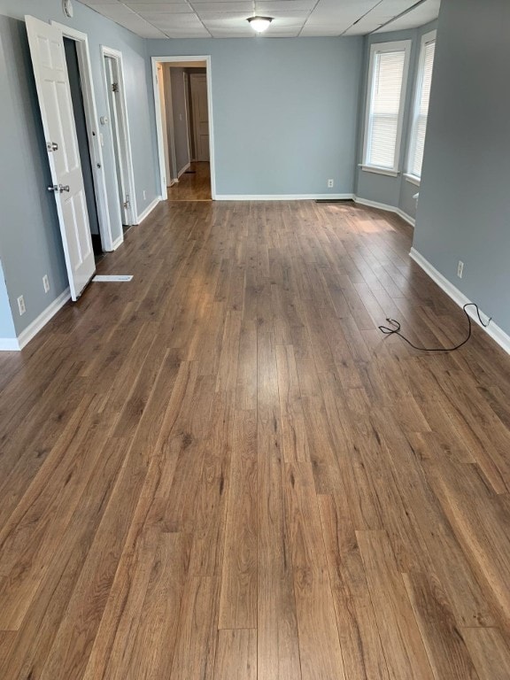 empty room featuring a drop ceiling and wood-type flooring