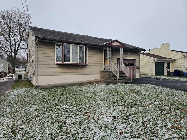 view of front of home with a garage and central AC