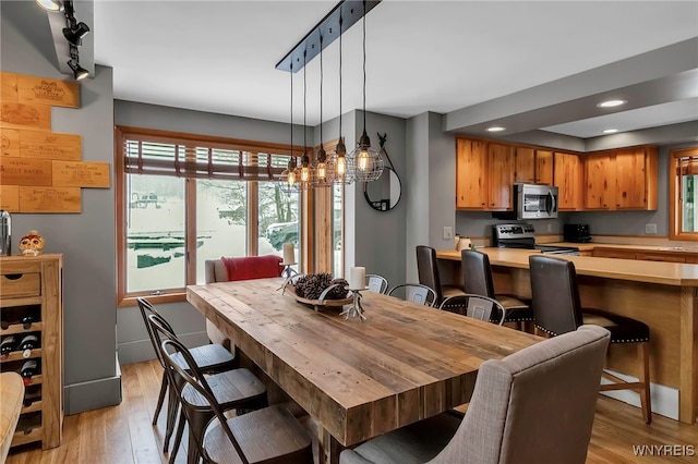 dining room with light hardwood / wood-style floors and a chandelier