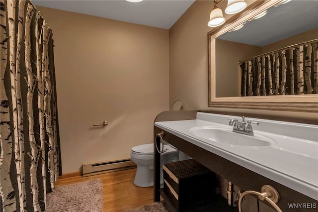 bathroom featuring hardwood / wood-style floors, a baseboard radiator, toilet, and sink